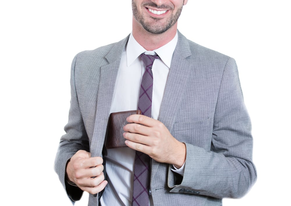 Closeup, cropped portrait of a smiling businessman reaching into his blazer pocket to get his wallet. Horizontal format isolated on white background. Business financial transaction